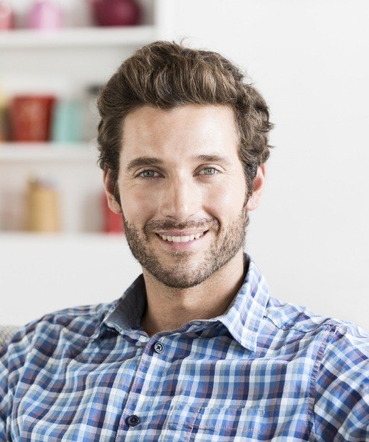 Young man in plaid shirt smiling after sleep treatments in Dallas