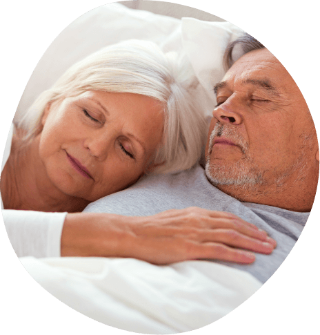 Older man and woman cuddling while sleeping