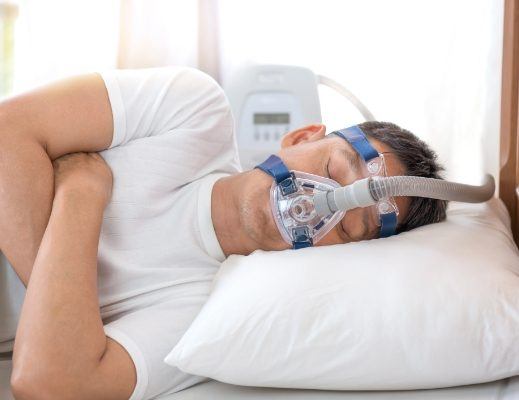 Man sleeping on his side while hooked up to C P A P machine