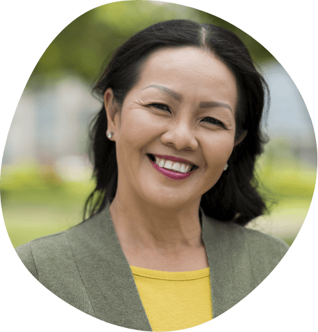 Woman in business jacket grinning outdoors