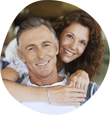 Older man and woman holding each other outdoors