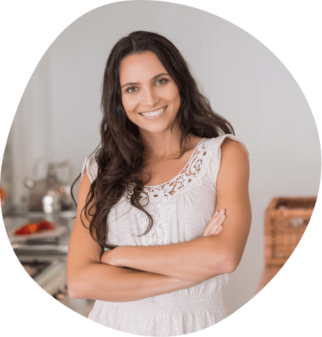Woman in white flowery blouse smiling with arms crossed