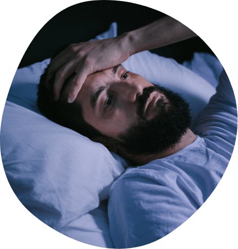 Bearded man lying awake in bed