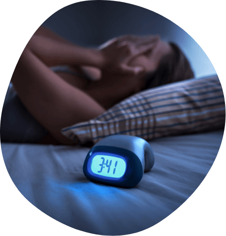 Woman lying awake in bed next to digital alarm clock reading 3 41 A M