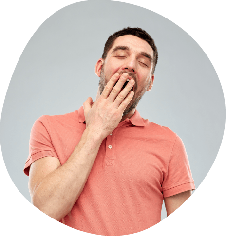 Man in orange polo shirt covering mouth with hand while yawning