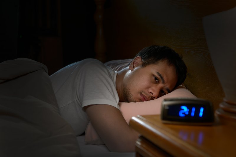 man with insomnia in bed