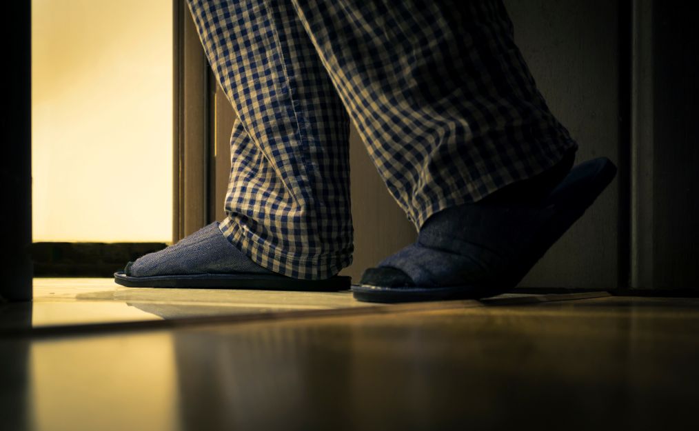 A man walking to the bathroom at night